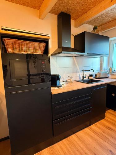 a kitchen with a black refrigerator and a sink at Ferienhaus ALTES FISCHERHAUS Kleve BED & BUBBLES in Kleve