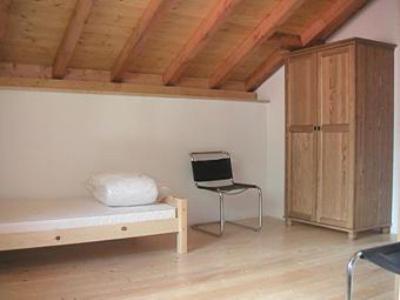 ein Zimmer mit einem Bett und einem Stuhl darin in der Unterkunft Rustico Al Noce in Riveo