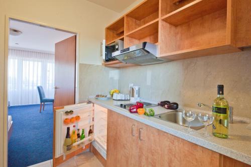 a kitchen with a sink and a bottle of wine at Apartment-Hotel Hamburg Mitte in Hamburg