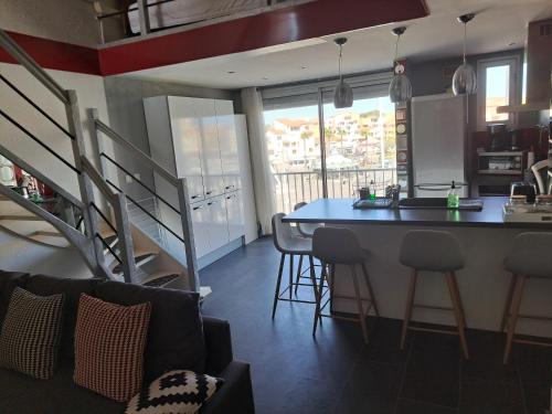 - une cuisine et un salon avec un comptoir et une table dans l'établissement Port Brescou, T3 en duplex climatisé, superbe vue sur le port, au Cap d'Agde