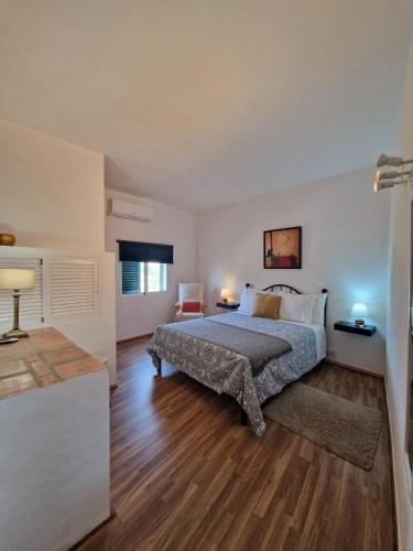 a bedroom with a bed and a chair in it at Alagoas Park in Loulé