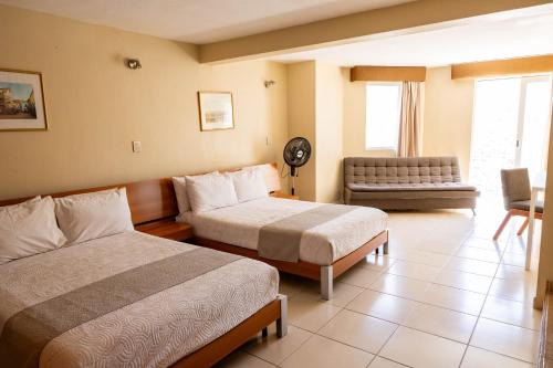 a hotel room with two beds and a couch at Hotel Balcón del Cielo in Guanajuato