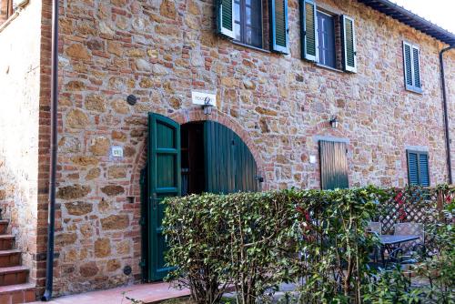 an old brick building with a green door at Borgo Il Poggio Agriturismo in Montaione