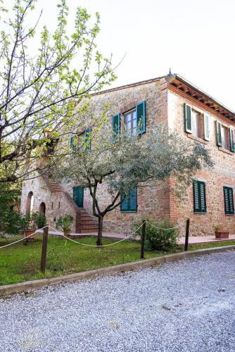 a brick building with a tree in front of it at Borgo Il Poggio Agriturismo in Montaione