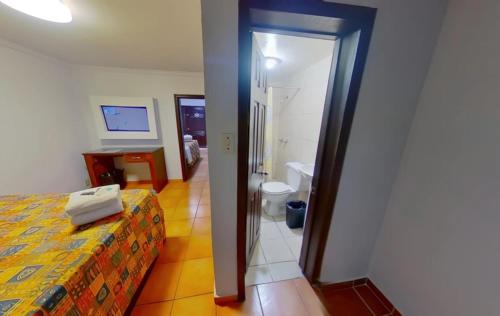 a hotel room with a bed and a bathroom at Hacienda del Indio in Mexicali