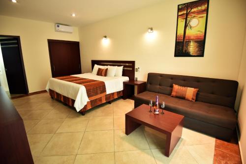 a hotel room with a bed and a couch at Hotel Quinta Tequisquiapan in Tequisquiapan