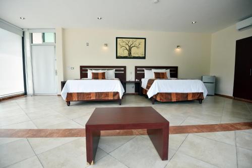 a hotel room with two beds and a table at Hotel Quinta Tequisquiapan in Tequisquiapan