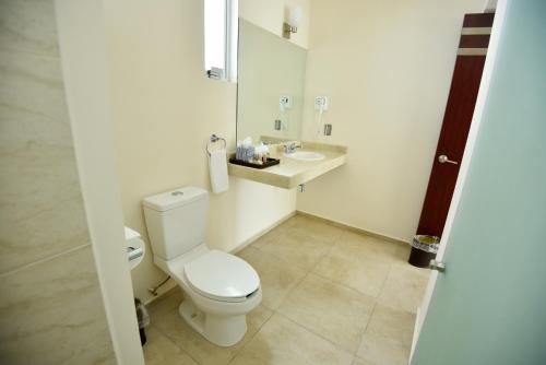 a white bathroom with a toilet and a sink at Hotel Quinta Tequisquiapan in Tequisquiapan