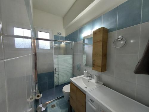 a bathroom with a sink and a toilet and a mirror at Oresti's House in Loutraki