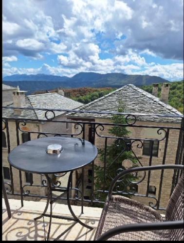 a table and chairs on a balcony with a view at Konstantinou & Elenis in Monodendri