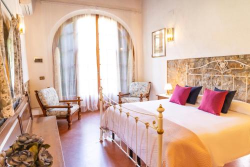 a bedroom with a large bed and two chairs at Borgo Il Poggio Agriturismo in Montaione