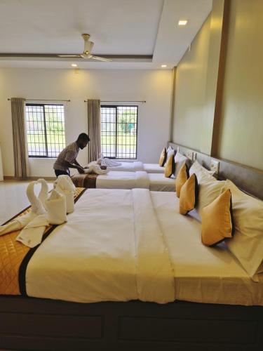 a man in a hotel room with a large bed at Alfa Inn in Nedumbassery