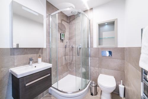a bathroom with a shower and a toilet and a sink at Stylish Retreats on Olympic Way in London