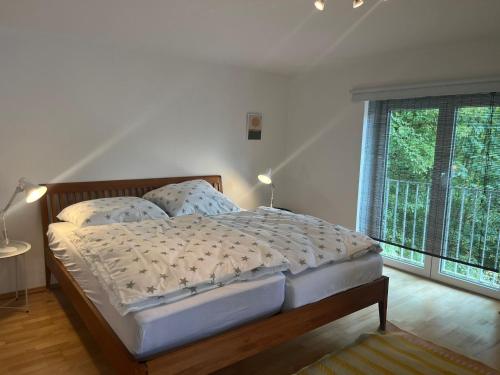a bedroom with a bed and a large window at Maisonette mit Kaminöfen Nähe Starnberger See und München in Münsing am Starnberger See