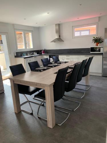- une grande table et des chaises en bois dans la cuisine dans l'établissement Etape du pont du canal, à Lupstein