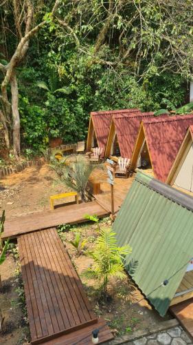 a group of wooden huts in a forest at Chalés Surfside Maresias in Maresias