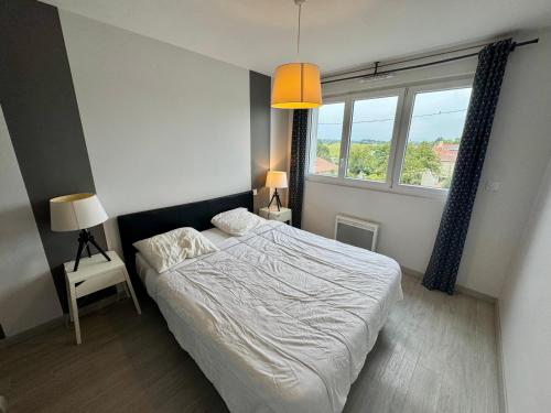 une chambre avec un lit et une grande fenêtre dans l'établissement Domaine des 5 Roses - Rose Sombre, à La Guierche