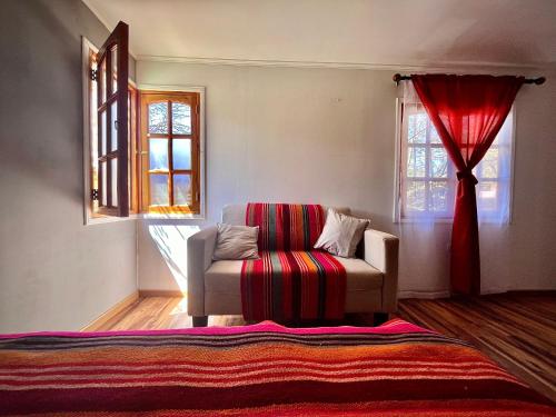 a living room with a chair and a window at Cabañas San Pedro de Atacama. in San Pedro de Atacama