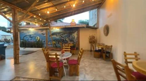 a dining room with a table and chairs and a mural at Hotel Berlín International in Puerto López