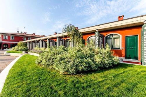 an orange building with a green door in a yard at Hotel Silver Milano in Milan