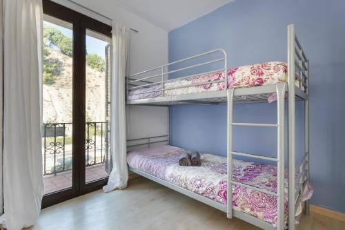 a bedroom with two bunk beds and a window at Arenyslux II in Arenys de Mar