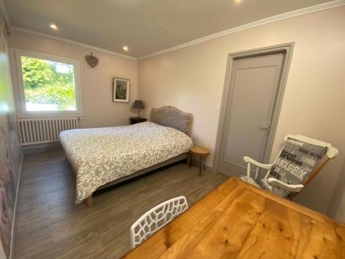 une chambre avec un lit, une fenêtre et un parquet dans l'établissement Parenthèse Océane Suite calme 1 ou 2 chambres entre bois et mer, à Perros-Guirec