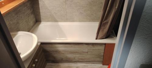 une petite salle de bain avec un lavabo et une baignoire dans l'établissement Résidence Aiguille Grive Bat Iii - Appartement 3 pièces 6 personnes à Arc 1800 au pied des pistes dans le quartier de Charmettoger MAE-0441, à Arc 1800
