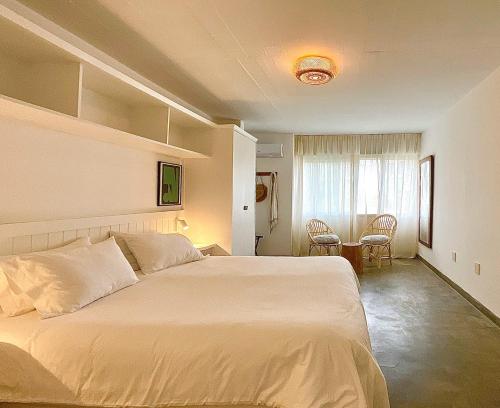 a bedroom with a large bed and a table at La Posta Beach Hotel in Punta del Este