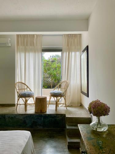 a bedroom with two chairs and a window at La Posta Beach Hotel in Punta del Este