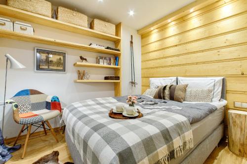 1 dormitorio con 1 cama con pared de madera en Apartament Chałubińskiego, en Zakopane