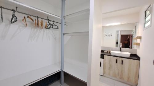 ein Badezimmer mit Waschbecken und Spiegel in der Unterkunft Résidence Paradis in Petit-Bourg