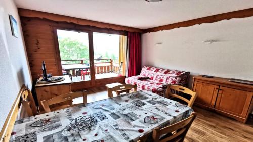 un salon avec une table, des chaises et un canapé dans l'établissement Résidence Hameau Des Ecrins - HEA910 - APPARTEMENT 1 CHAMBRE + COIN MONTAGNE - TERRASSE VUE MONTAGNES MAE-2211, à Narreyroux
