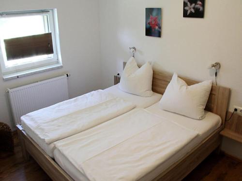 a large white bed in a room with a window at Holiday apartment Villa Sonja in Zützen
