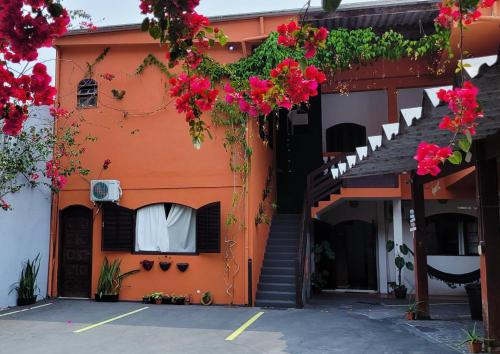 an orange building with flowers hanging from it at Aldeia Ubatuba in Ubatuba