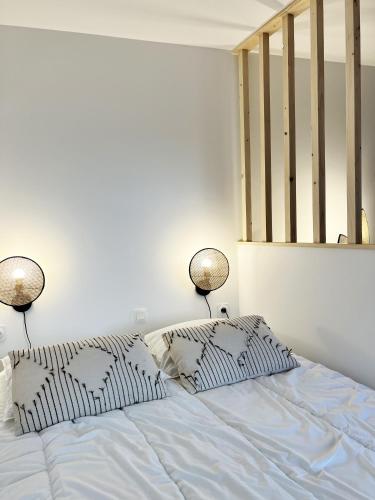 une chambre avec un lit avec deux lampes dessus dans l'établissement Jungle home, à Rodez