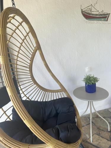 a rattan chair in a room with a table at La Casa Pacifica in Nea Moudania