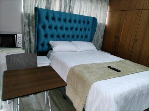 a hotel room with two beds and a table and a chair at Willow Guest house in Vereeniging