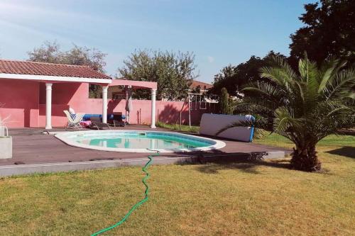 - une piscine avec un tuyau vert dans la cour dans l'établissement Villa avec piscine, Spa, terrain de pétanque, baby foot, ping pong, à Labarthe-sur-Lèze