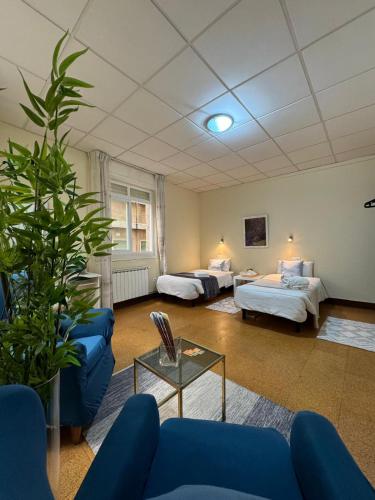 a room with two beds and a couch and a table at Hostal Real in Vigo