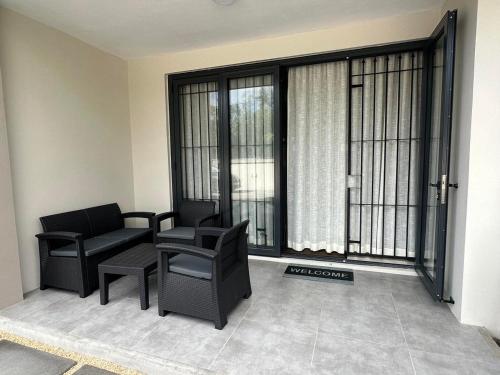a living room with a couch and a chair and windows at SeaSand-Entire Luxury 3 BD condo - Close to beach in Flic-en-Flac