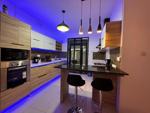 a kitchen with a island with bar stools in it at SeaSand-Entire Luxury 3 BD condo - Close to beach in Flic-en-Flac