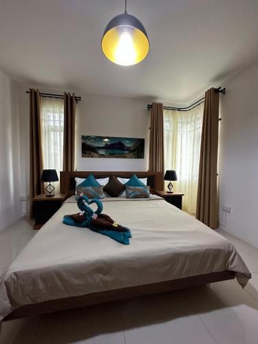 a bedroom with a large bed with a stuffed animal on it at SeaSand-Entire Luxury 3 BD condo - Close to beach in Flic-en-Flac
