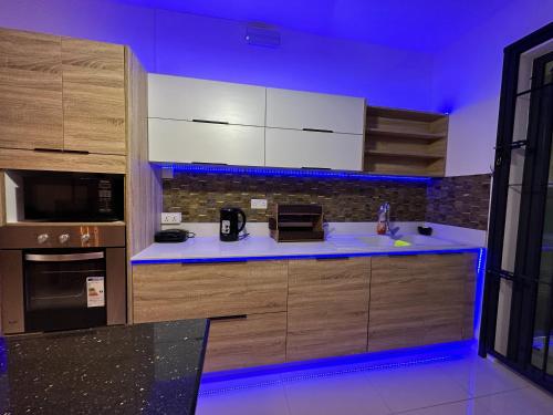 a kitchen with white cabinets and a blue lighting at SeaSand-Entire Luxury 3 BD condo - Close to beach in Flic-en-Flac