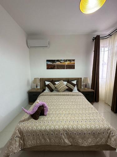 a bedroom with a bed with a purple stuffed animal on it at SeaSand-Entire Luxury 3 BD condo - Close to beach in Flic-en-Flac