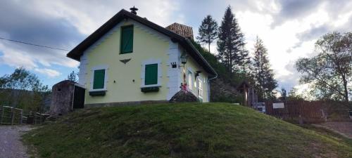 a small house on top of a grassy hill at Békény Kulcsosház in Gheorgheni