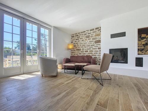 un salon avec un canapé, une table et des chaises dans l'établissement Maison Bord de Plage avec Piscine, Sauna, Bains à Remous, Volley, à Plouguerneau