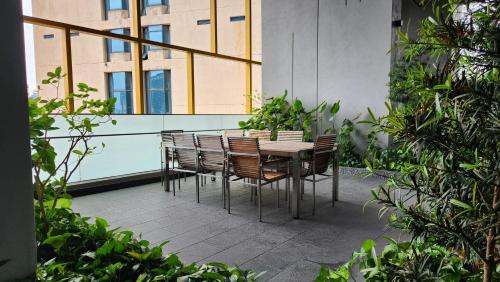 a table and chairs on a patio with a building at Opus Residences Kuala Lumpur by Infini Suites in Kuala Lumpur
