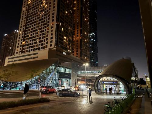 a city at night with cars parked in a parking lot at Nomad Partition Room in Barsha Heights 3 mins to ICM Metro in Dubai