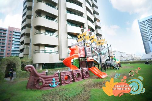 a playground in front of a tall building at Nomad Partition Room in Barsha Heights 3 mins to ICM Metro in Dubai
