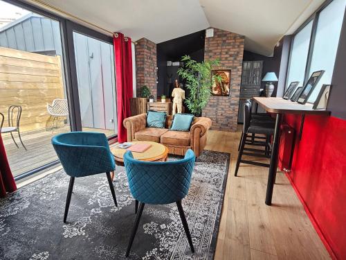 un salon avec des chaises bleues et une table dans l'établissement Stylish 53m2 Suite in Paris - Terrace, Balcony, Free Parking & 5mn from Metro, à Ivry-sur-Seine